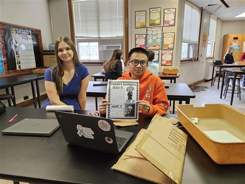 Male and female student showing their makerspace projects for Black History Month. Male holding paper with cardboard in front